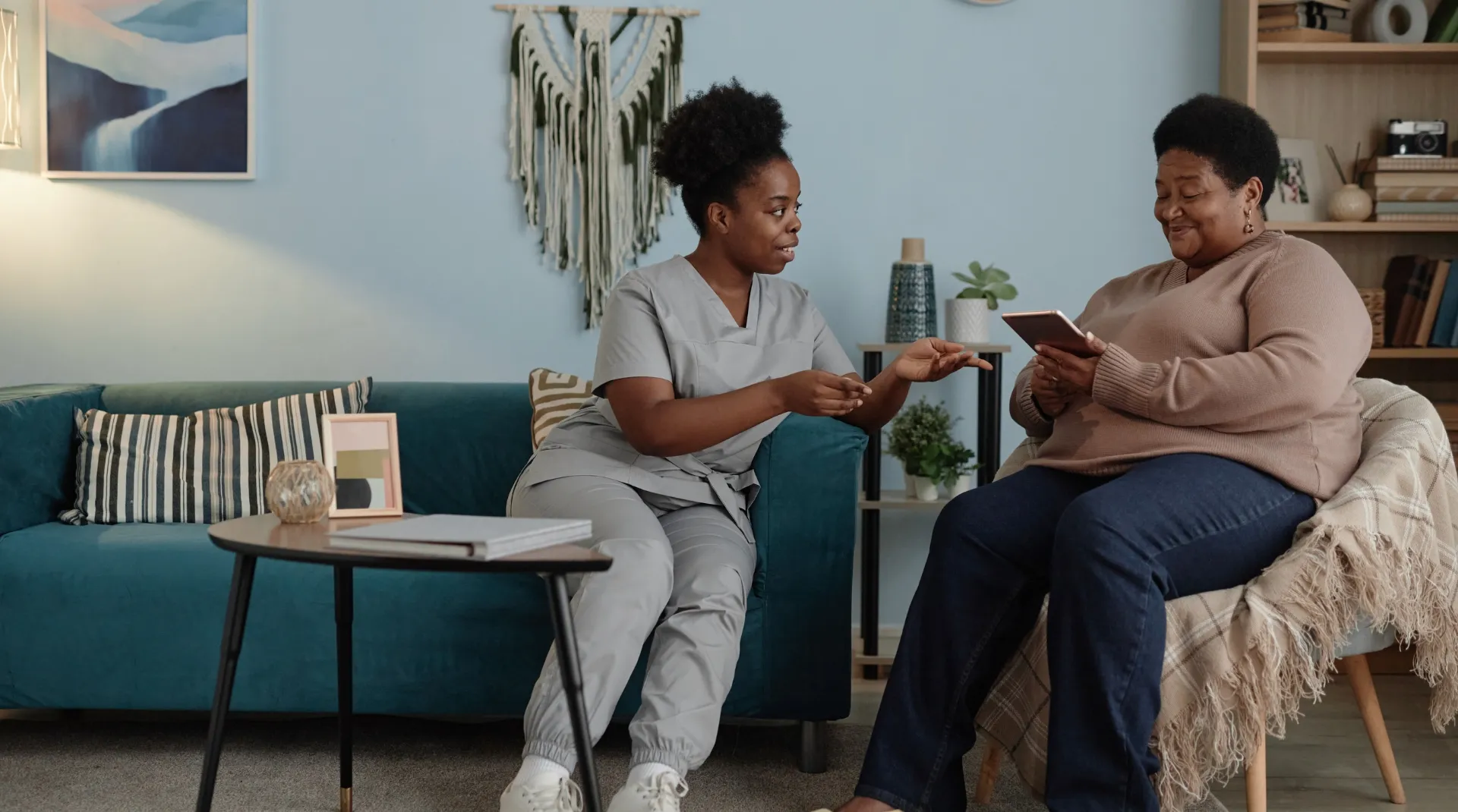 Companion caregiver talking warmly with a client on the couch
