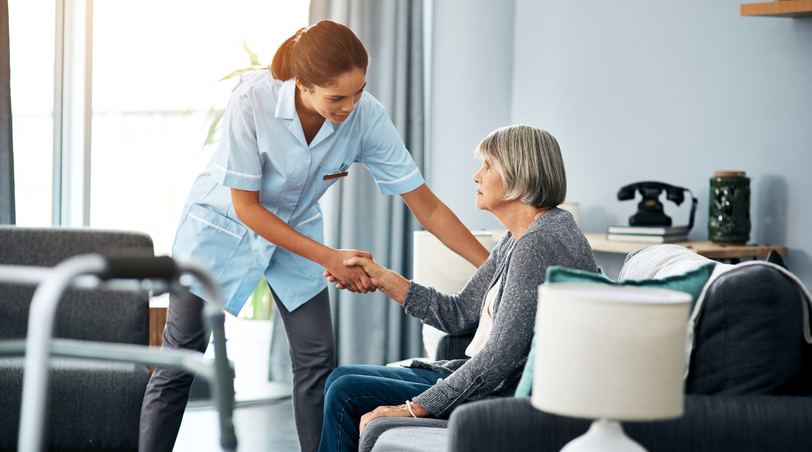 A Faithful Touch caregiver gently helping a senior woman stand at home